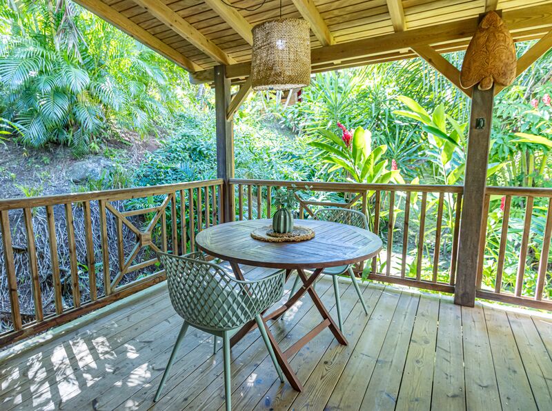 Table en terrasse avec deux chaises dans la villa Ti Kaz Bwa du Caraïb'Bay Hôtel